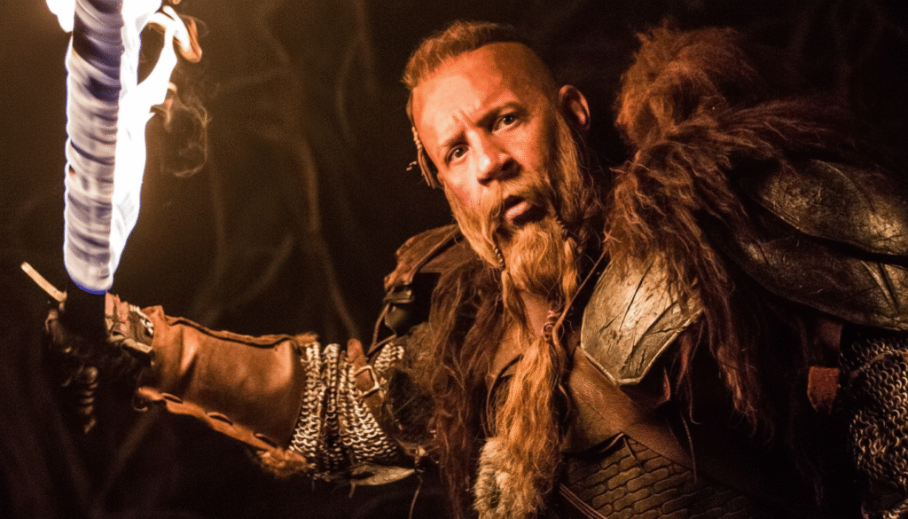 Armored warrior holding a flaming sword in a dark fantasy scene from The Last Witch Hunter, symbolizing ancient magic and battle.