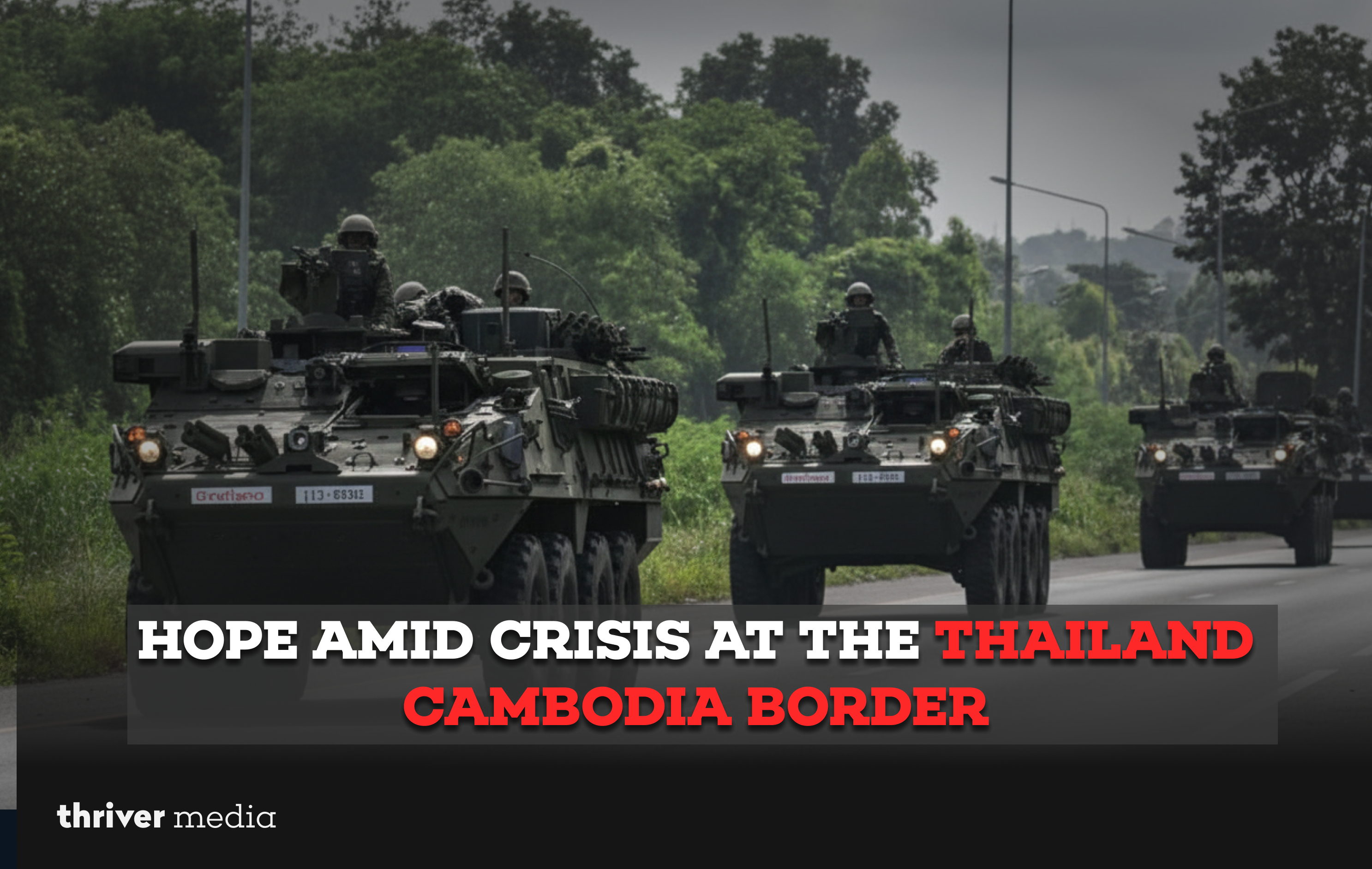 Current image: Armored vehicles with troops moving along a forested road near the Thailand–Cambodia border during a period of conflict.