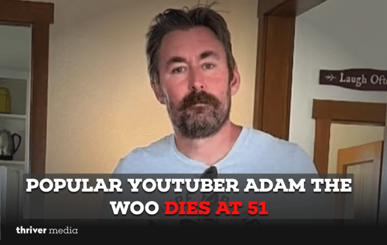 Adam the Woo filming at a Disney park, smiling with a camera in hand.