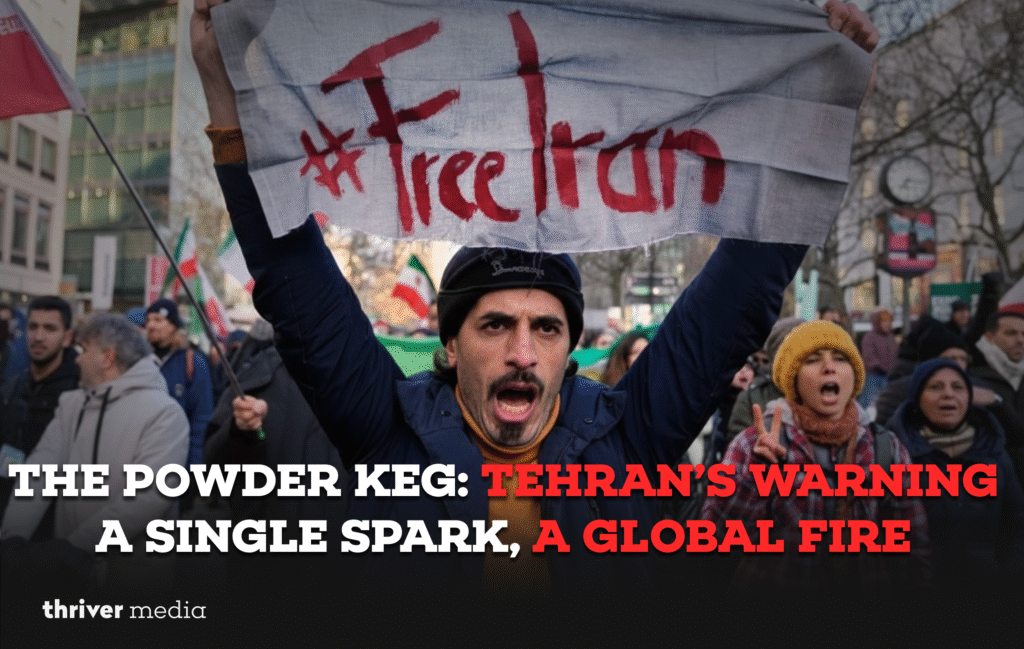 Current image: Protester holding a “#FreeIran” banner during a large demonstration, symbolizing rising unrest as headlines warn of Tehran’s escalating tensions and global conflict risk.