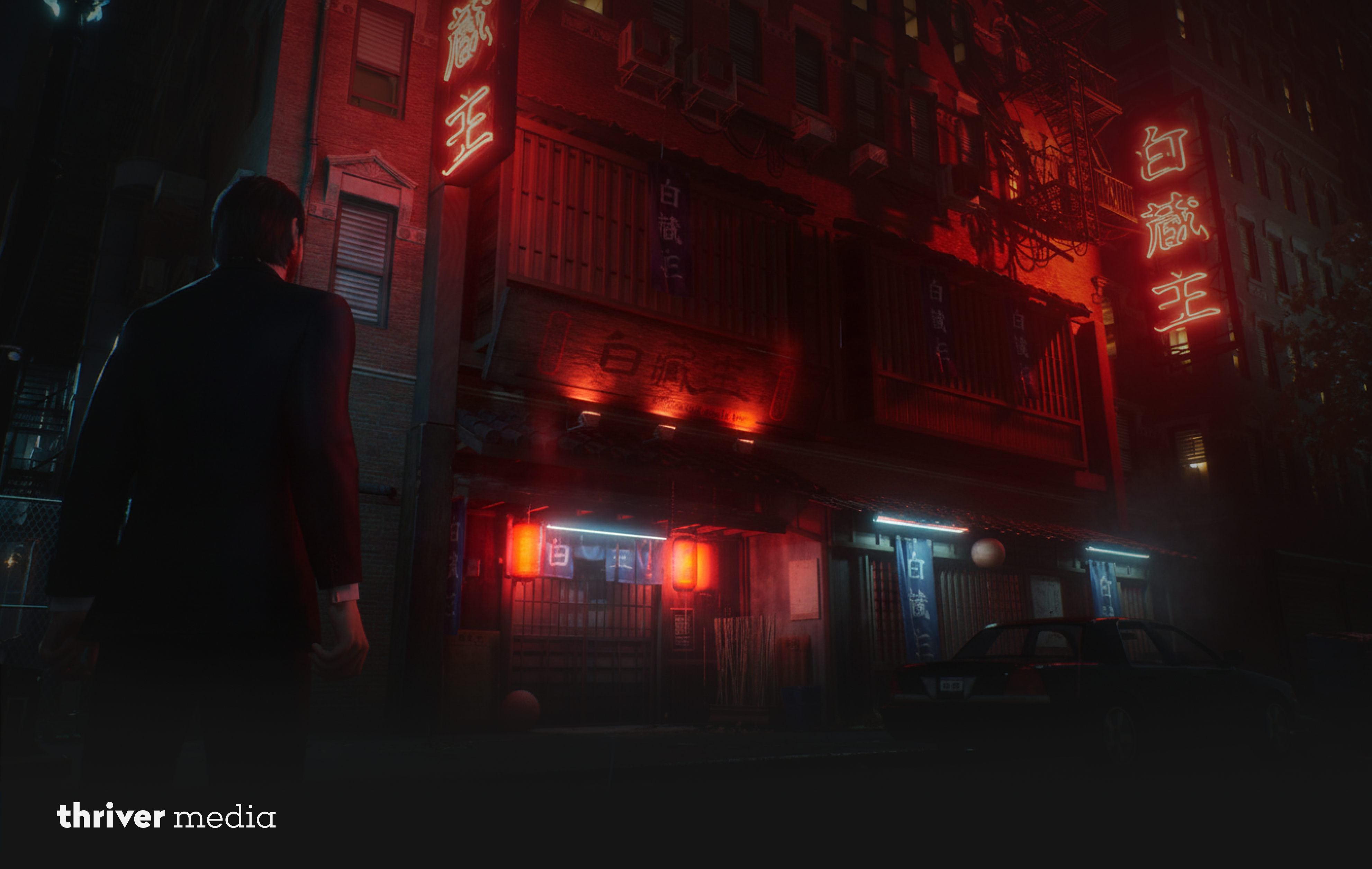 A man in a black suit stands on a dark city street at night, facing a Japanese-style building glowing with red neon signs and lanterns.