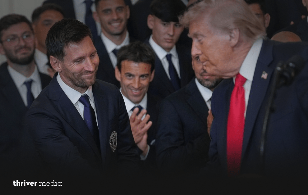 Lionel Messi smiles while greeting Donald Trump during a White House ceremony with Inter Miami players in the background.