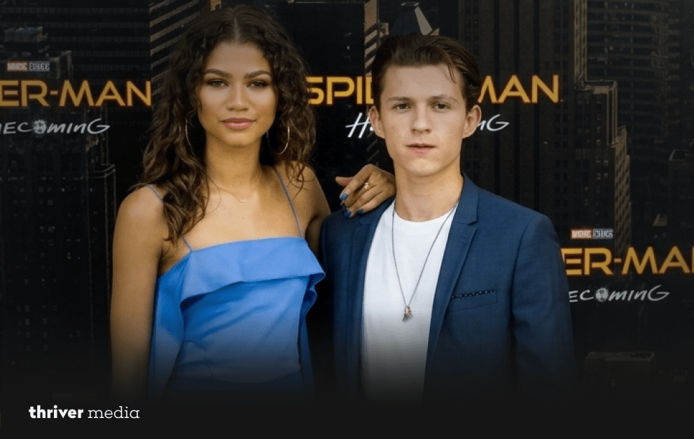 Zendaya and Tom Holland pose together on the red carpet at a Spider-Man: Homecoming event.